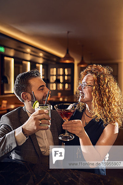 Glückliches Paar beim geselligen Beisammensein in einer Bar