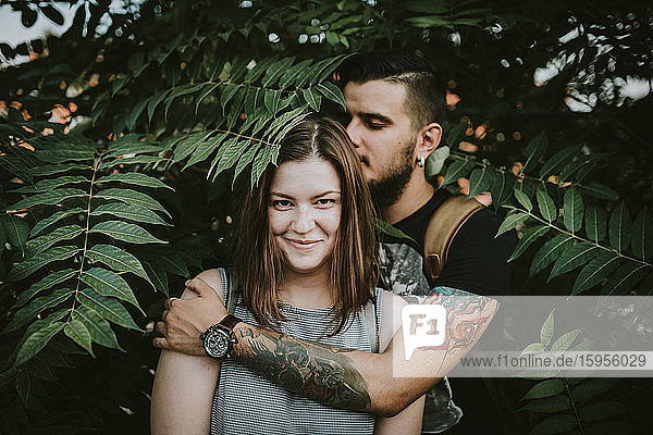 Portrait of affectionate young couple in shrubbery