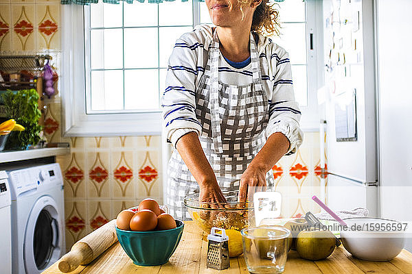 Frau bereitet in ihrer Küche einen Kuchen zu