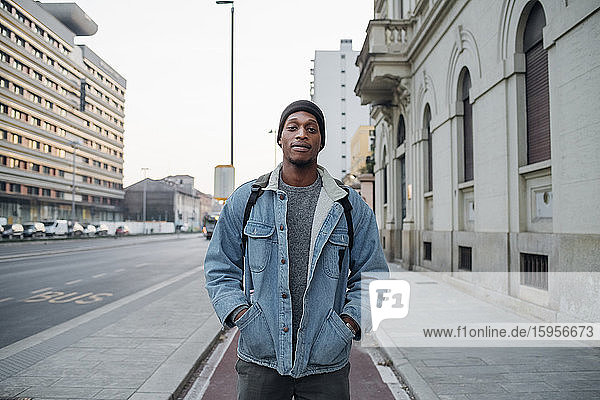 Portrait of young man standing on bicycle lane in the city  Milan  Italy