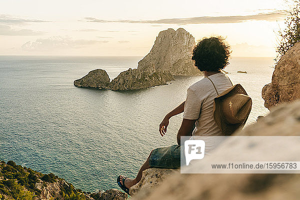 Man sitting on rock watching sunset  Ibiza  Spain