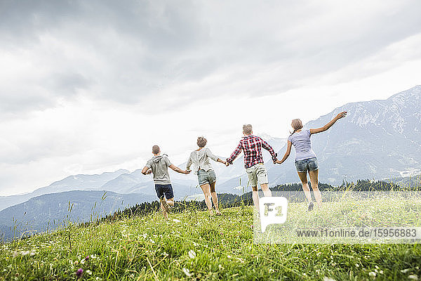 Friends running on a meadow in the mountains  Achenkirch  Austria