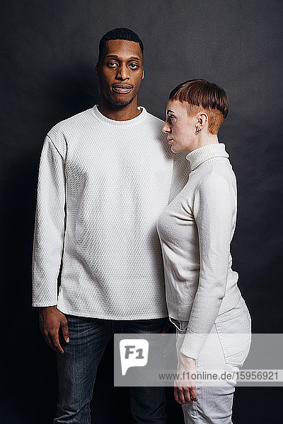 Studioporträt eines gemischtrassigen Paares mit weißen Pullovern