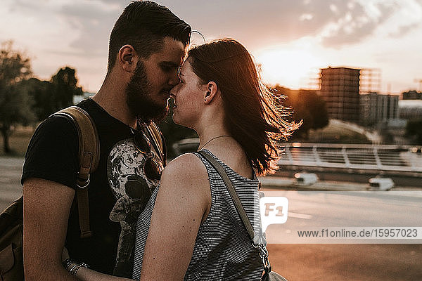 Affectionate young couple embracing at a street at sunset  Berlin  Germany
