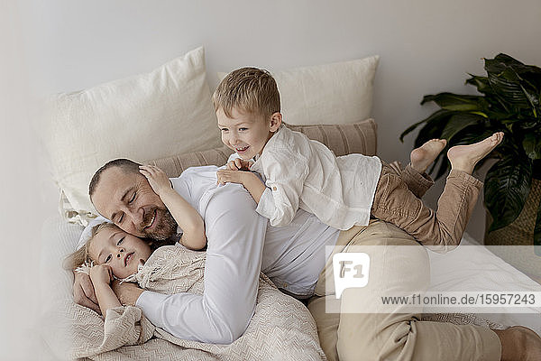Familienporträt eines glücklichen Vaters und seiner beiden Kinder zu Hause