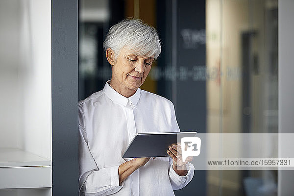 Portrait of senior businesswoman using digital tablet in office