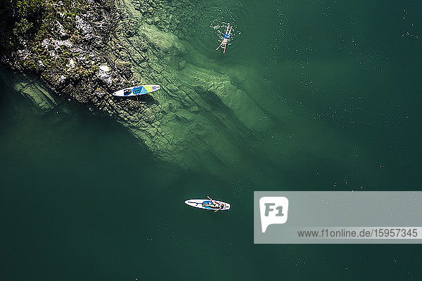 Deutschland,  Bayern,  Luftaufnahme von zwei Paddelboardern,  die sich am grünen Ufer des Walchensees entspannen