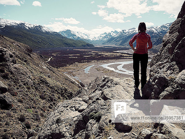 Rückansicht einer Frau auf einem Felsen  die die Aussicht auf die Berge bewundert  El Chalten  Argentinien