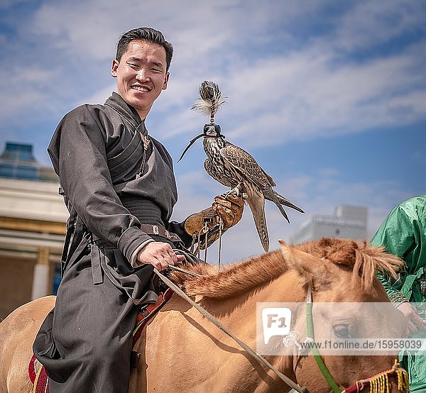Junger Jäger mit ausgebildetem Falken auf dem Pferd Stadt Ulaanbaatar Mongolei Asien