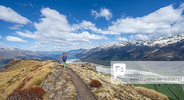 Panoramic view  hiker on the summit of Mount Alfred  view of Lake Wakatipu and mountain scenery  Glenorchy near Queenstown  Southern Alps  Otago  South Island  New Zealand  Oceania