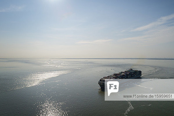 Schrägansicht eines großen Containerschiffes das auf den Hafen von Antwerpen Belgien zusteuert.