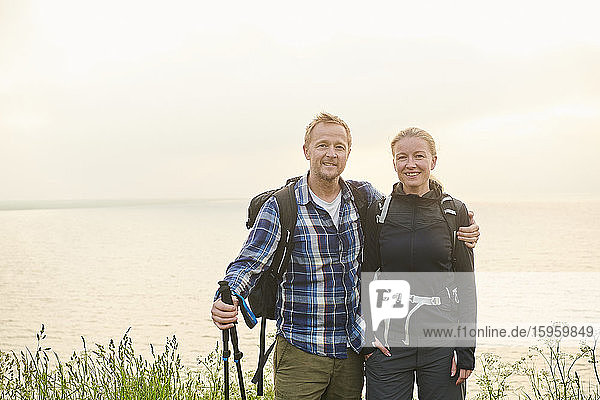 Two hikers  man and woman  embracing on a coastal path