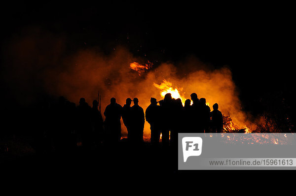 Group of people standing around a fire  Bavaria  Germany