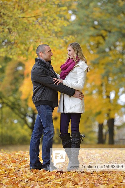 Happy couple embracing in autumnal landscape