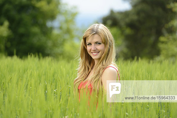 Blonde junge Frau in einem Kornfeld