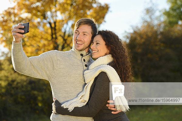 Fröhliches Paar im Herbst macht ein Selbstportrait