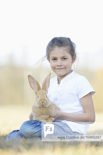 Mädchen mit ihrem Kaninchen auf der Wiese  Oberpfalz  Bayern  Deutschland  Europa