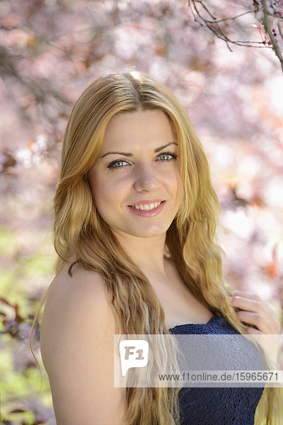 Young woman at blooming cherry tree  portrait