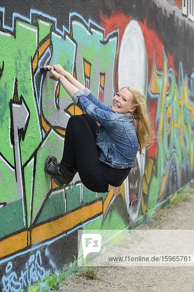 Young woman at a graffiti wall  Nuremberg  Bavaria  Germany  Europe