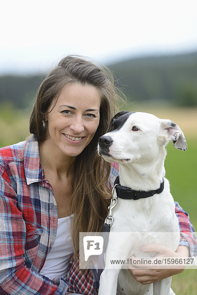 Frau mit einem Hund auf einer Wiese  Bayern  Deutschland  Europa