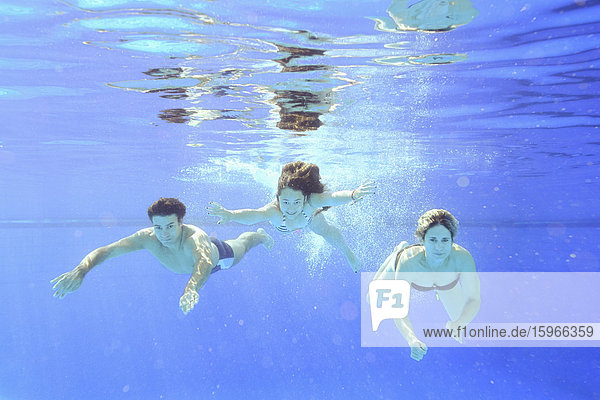 Familie beim Schwimmen unter Wasser in einem Freibad
