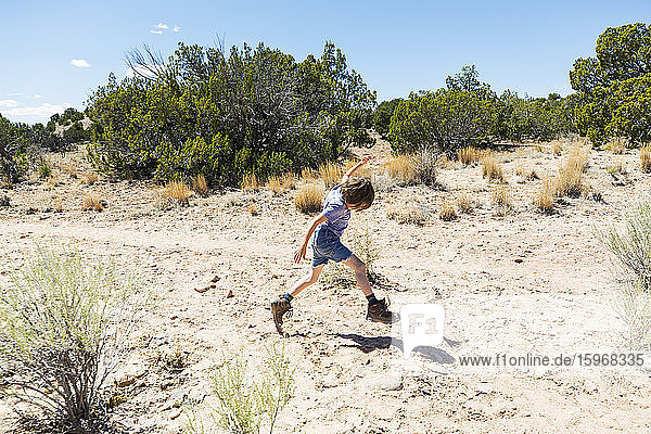 6 year old boy leaping on hiking trail