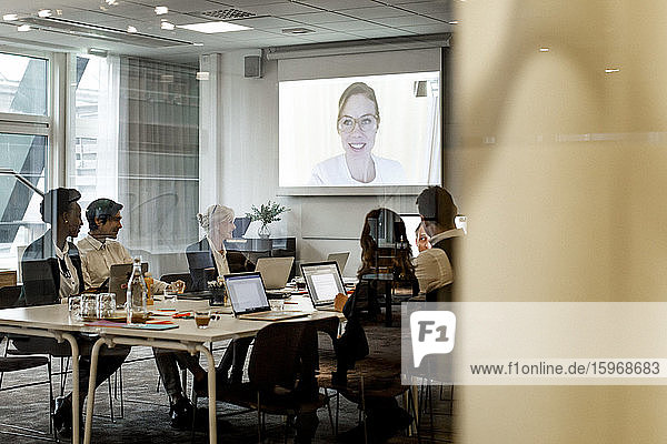 Business colleagues having meeting through video conference in board room at workplace