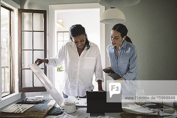Female architects working at table in home office