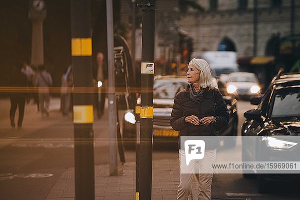 Ältere Frau schaut beim Spaziergang in der Stadt weg