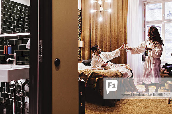 Ehepaar genießt Champagner im Hotelzimmer während des Urlaubs