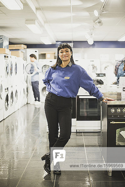 Porträt einer lächelnden Verkäuferin  die in einem Elektronikladen steht