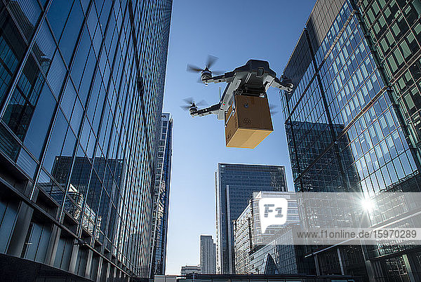 Drohne liefert Paket zwischen Hochhäusern  London  UK
