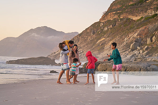 Family playing on ocean beach