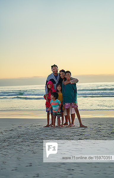 Portrait happy affectionate family on sunset ocean beach