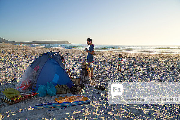 Family relaxing and playing at tent on ocean beach  Cape Town
