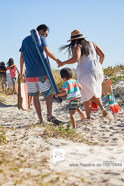 Familienspaziergang im Sand am sonnigen Strand