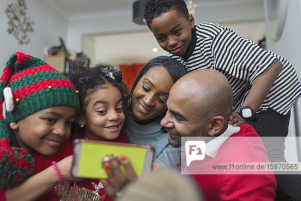 Glückliche Familie nimmt Weihnachts-Selfie mit Smartphone