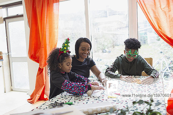 Mutter und Kinder backen Weihnachtsplätzchen bei Tisch