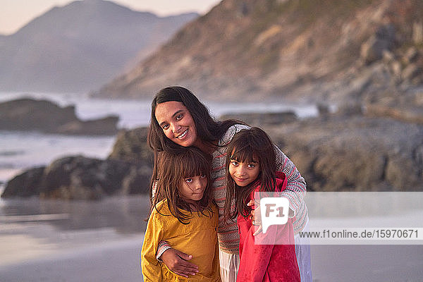 Porträt glückliche Mutter und Töchter am Strand