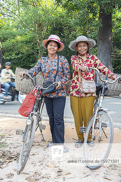 Zwei einheimische Frauen mit ihren Fahrrädern lächeln zusammen in Siem Reap  Kambodscha  Indochina  Südostasien  Asien