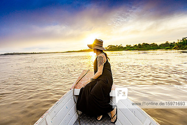 Frau genießt Sonnenuntergang am Fluss  Amazonas  Peru  Südamerika