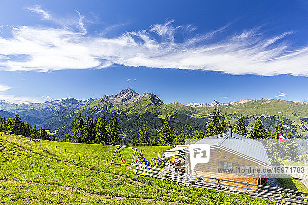Alphütte mit Schweizer Fahne unter herrlichen Wolken  Urses  Surselva  Graubünden  Schweiz  Europa