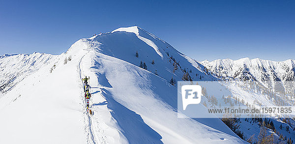 A team of three skiers advances on the mountain ridge  Mount Meriggio  Valtellina  Lombardy  Italy  Europe