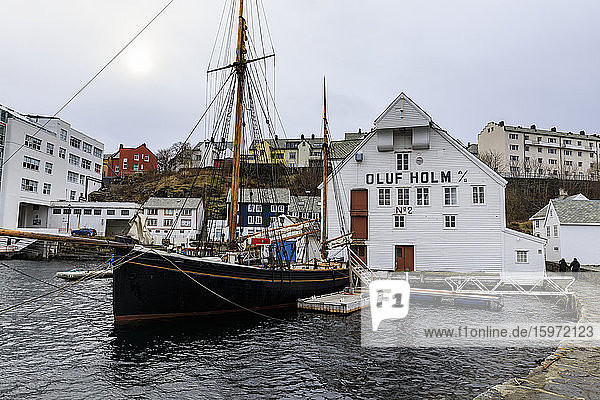 Wunderschönes Alesund  Hafenviertel  historisches Boot  Holzlagerhaus im Winter  Alesund  More og Romsdal  Norwegen  Skandinavien  Europa