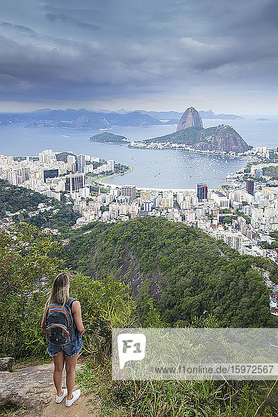 A female hiker looking out over the landscape of Rio to Sugar Loaf mountain from Tijuca National Park  Rio de Janeiro  Brazil  South America