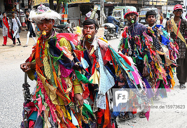 Adivasi-Dorfbewohner feiern Holi  indem sie sich in bunte Lumpen kleiden und andere Dörfer besuchen  Gujarat  Indien  Asien