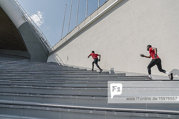 Sportler mit Gesichtsmasken beim Treppensteigen