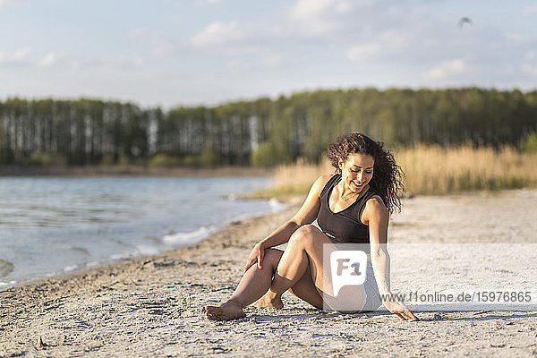 Glückliche junge Frau beim Entspannen am Strand