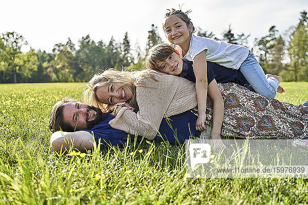 Happy family lying on grass during sunny day
