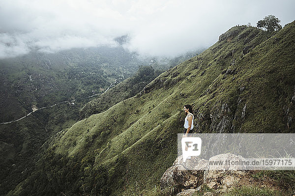 Sri Lanka  Provinz Uva  Ella  Wanderin steht auf einem Felsblock am Little Adams Peak